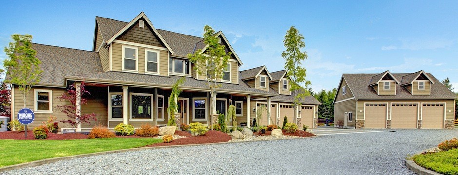 Large farm country house with gravel driveway and green landscape.