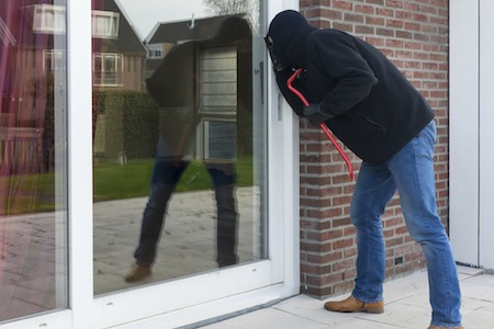 Mean looking burglar enters a house