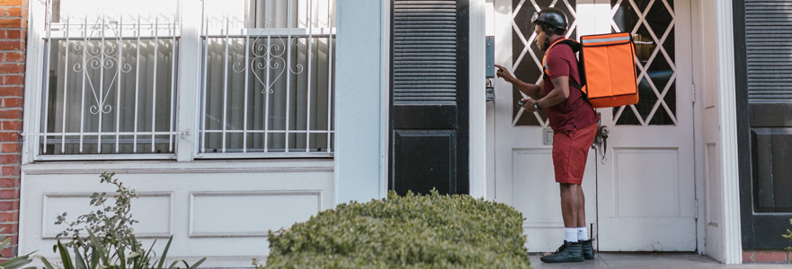 Package delivery person using a home intercom system at the front door - Moore Protection