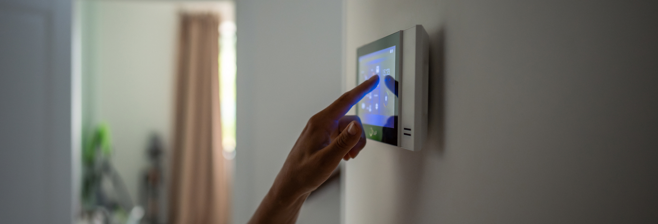 A home owner touches a smart home panel